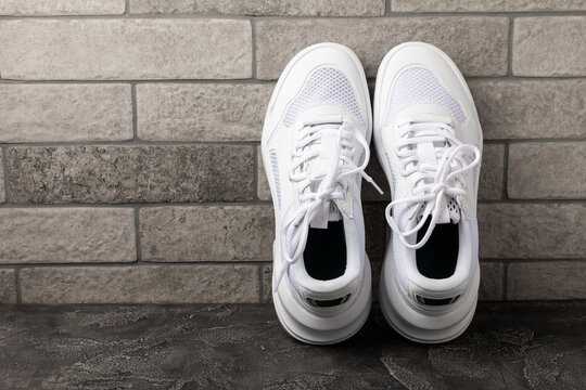 White sneakers on a black textured background.Fashion.UNISEX. Sports shoes sneakers for active lifestyle.Product photo and levitation concept.Street style.Copy space.Place for text.
