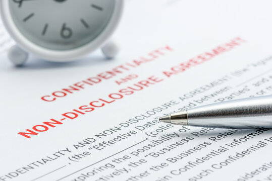 Confidentiality And Non-disclosure Agreement Form And A Pen, Business Legal Document Concept. Confidentiality Agreement Is Legal Contract Between Two Parties That Outlines Confidential Issues Together