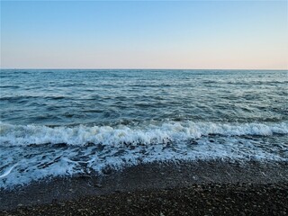 Seascape. Blue sea, blue sky, rocky beach. Summer day. Clear weather.