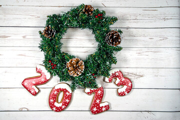 Christmas wreath with the numbers 2023 on a white wooden background.