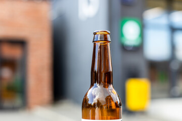 open brown glass bottle close up outdoors in summer evening
