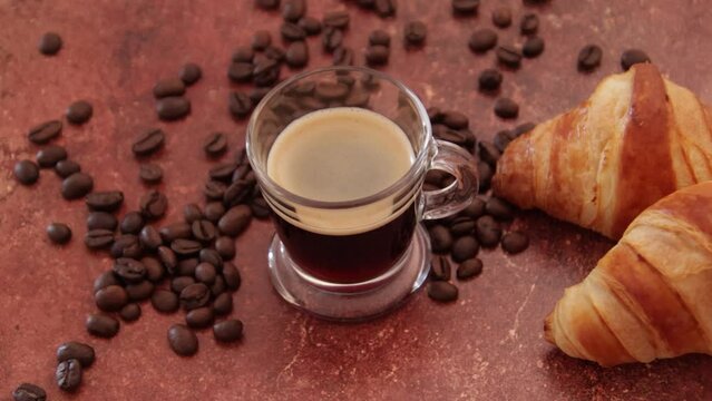 tasse de caf&eacute; et croissant sur une table	