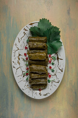 Dolma, cabbage rolls in grape leaves, Traditional Armenian dish, with white sauce, top view, close-up, selective focus,