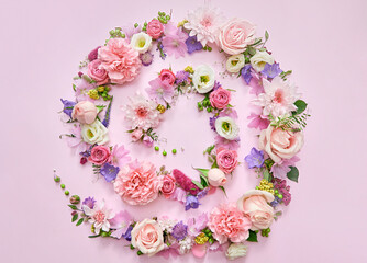 Many different pink lilac violet white pastel flowers mix and green leaves petals spiral on floral background. Blossom composition creative flatlay. Floristic decoration ads. Top view above, flat lay.