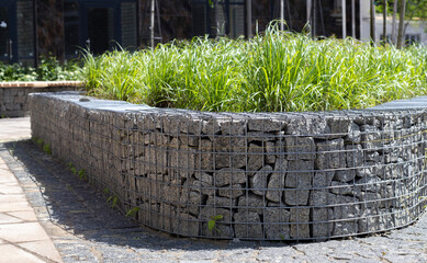 Basket support wall made of granite gabion. Gabions in the garden. Modern Gabion fence with stones...