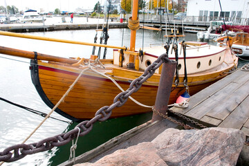 Wood sailboat moored in marina.