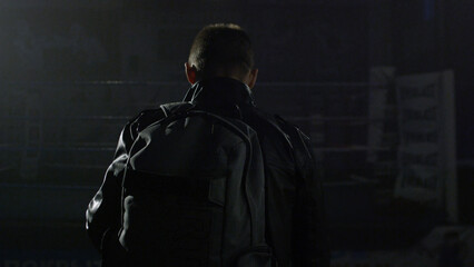 Fototapeta na wymiar Man in a jacket and bag in the gym. Man going with bag after training. Man going to the gym