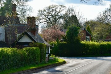 Fototapeta na wymiar View of a village street with red brick houses in spring, Berkswell, West Midlands, Englands, UK