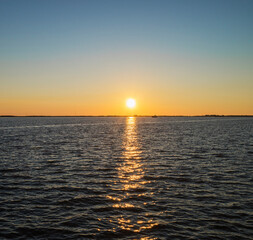 Obraz premium the setting sun on the background of the river with the reflection of the sun in the river.evening sky.