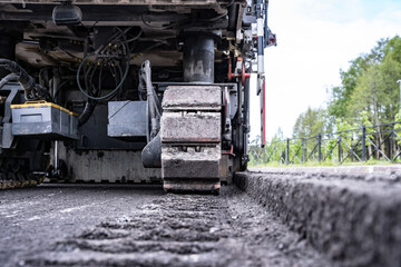 rear view of a cold milling machine and cut asphalt on the road