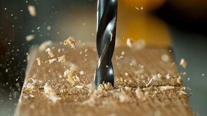 Freeze motion of a drill bit drilling into wood, macro shot