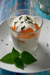 Balls of cantaloupe melon in a glass, served with coconut milk with mascarpone and lime juice and mint.