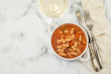 boiled white beans with vegetables and sauce on white bowl