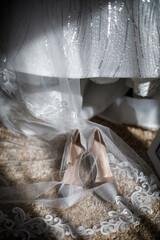 Wedding shoes stand next to the dress