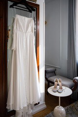 Fototapeta na wymiar Wedding dress hanging on the mirror