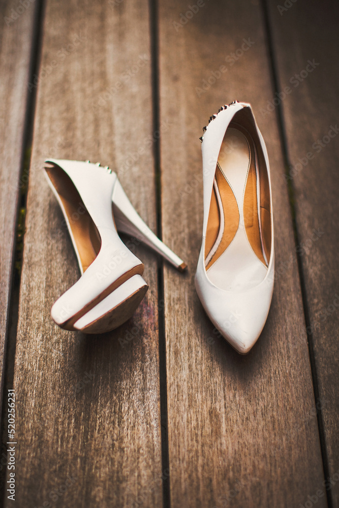 Poster Wedding shoes stand on a wooden floor