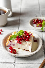Homemade cottage cheese casserole garnished with sauce, redcurrant and mint leaf on gray tile background