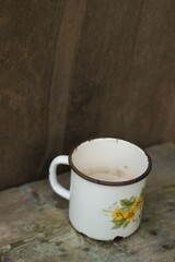 An old metal mug on an old table 