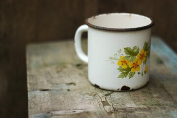 An old metal mug on an old table 