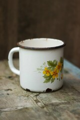 An old metal mug on an old table 