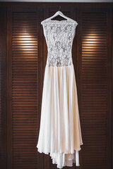 Wedding dress hanging on a wooden wardrobe