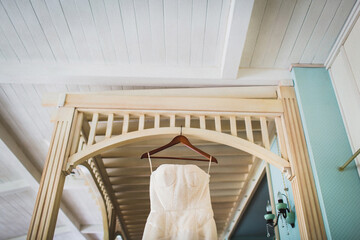 Fototapeta na wymiar Wedding dress hanging on a wooden arch