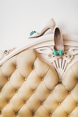 Beige wedding shoes hanging on the sofa