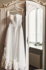 Wedding dress hanging on a white wardrobe