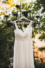 Wedding dress hanging on a chandelier in the garden
