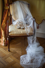 Wedding shoes with veil on vintage armchair