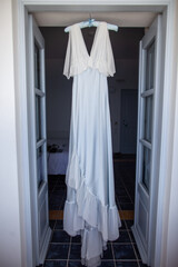 Fototapeta na wymiar Wedding dress hanging on the door arch
