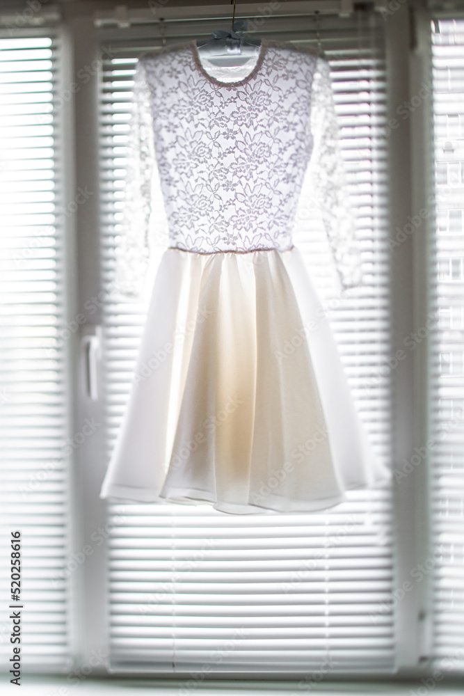 Poster short wedding dress hanging on the window