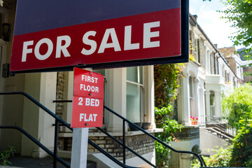 Estate agent 2 Bed Flat For Sale sign on street of houses- UK