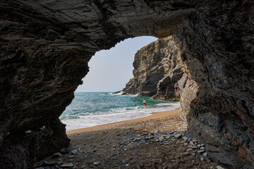 Cave by the sea and man taking a bath. Calblanque Regional Park in Murcia
