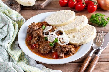 Traditional czech goulash with dumplings on table