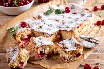 Sponge cake or chiffon cake with cherries, so soft and delicious with ingredients on wooden table....