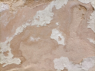  The surface of an old dilapidated wall with peeling off plaster in beige and pink shades. Abstract...