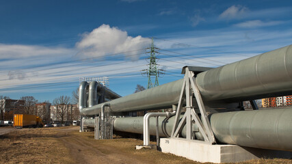 pipeline and power line pylon, in the photo, pipeline close-up, power line pylon and blue sky in the background