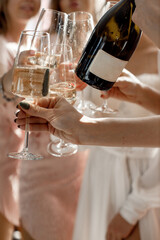 Bride and bridesmaids clink glasses at a wedding