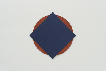 blue paper square (diamond orientation) on a brown circle