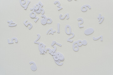 white paper numbers scattered on blank paper