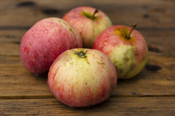 Apples on a wooden table in the garden after rain