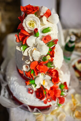 Multilevel wedding cake on the table decorated with roses