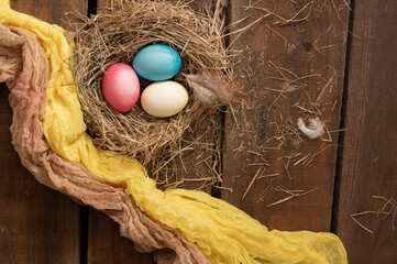 Painted Easter chicken eggs in a nest. Holiday Easter concept background. High quality photo