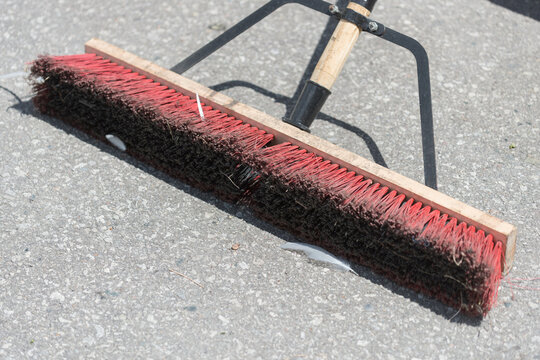 Push Broom With Orange Bristles In The Sun