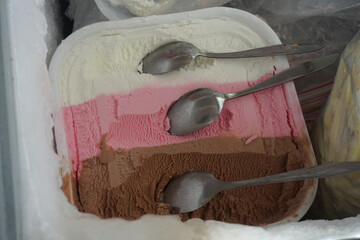 vanilla, strawberry, chocolate ice cream in the freezer. scrape the ice cream.