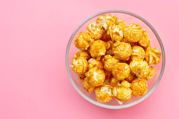 Honey caramel popcorn on pink background.