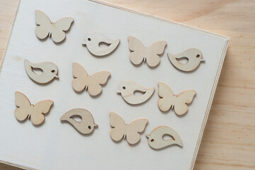 wooden bird and butterfly shapes on a wooden object