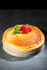 Homemade Traditional Cheesecake with fresh mint and sliced strawberries.