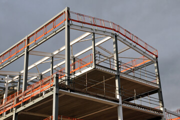 steel frame and roof of a building under construction with orang